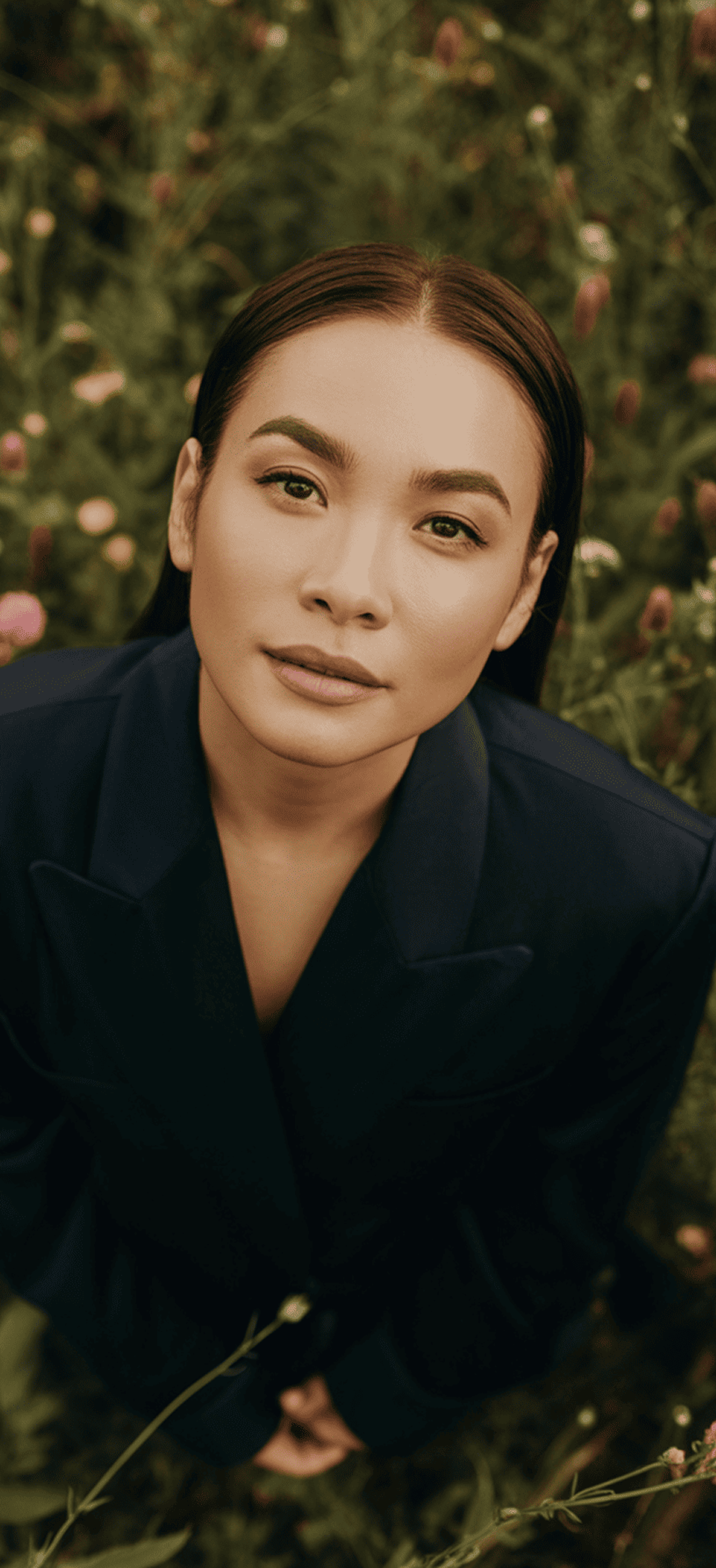 Woman in a flower field looking up