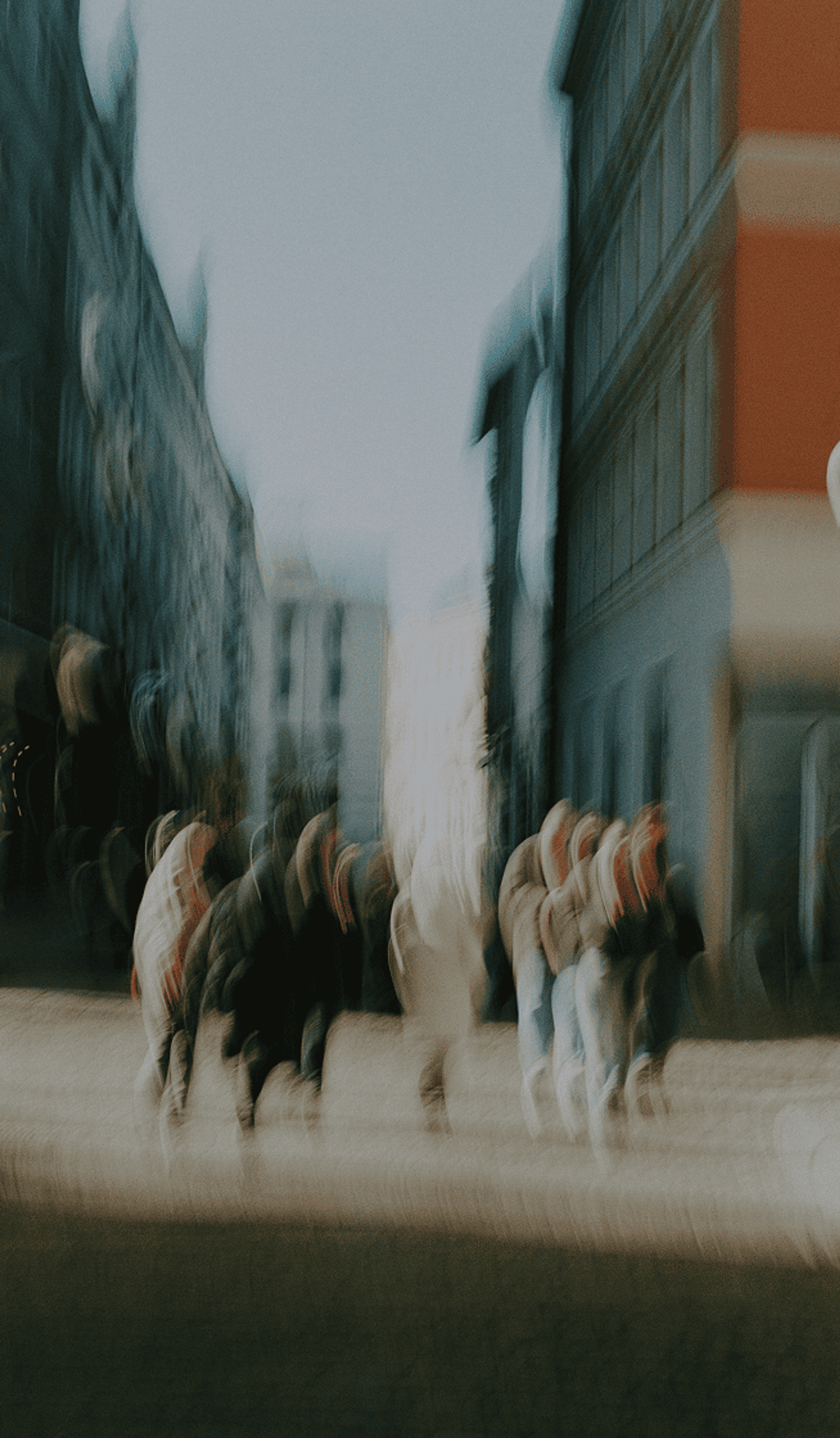 Motion-blurred people walking through a city street