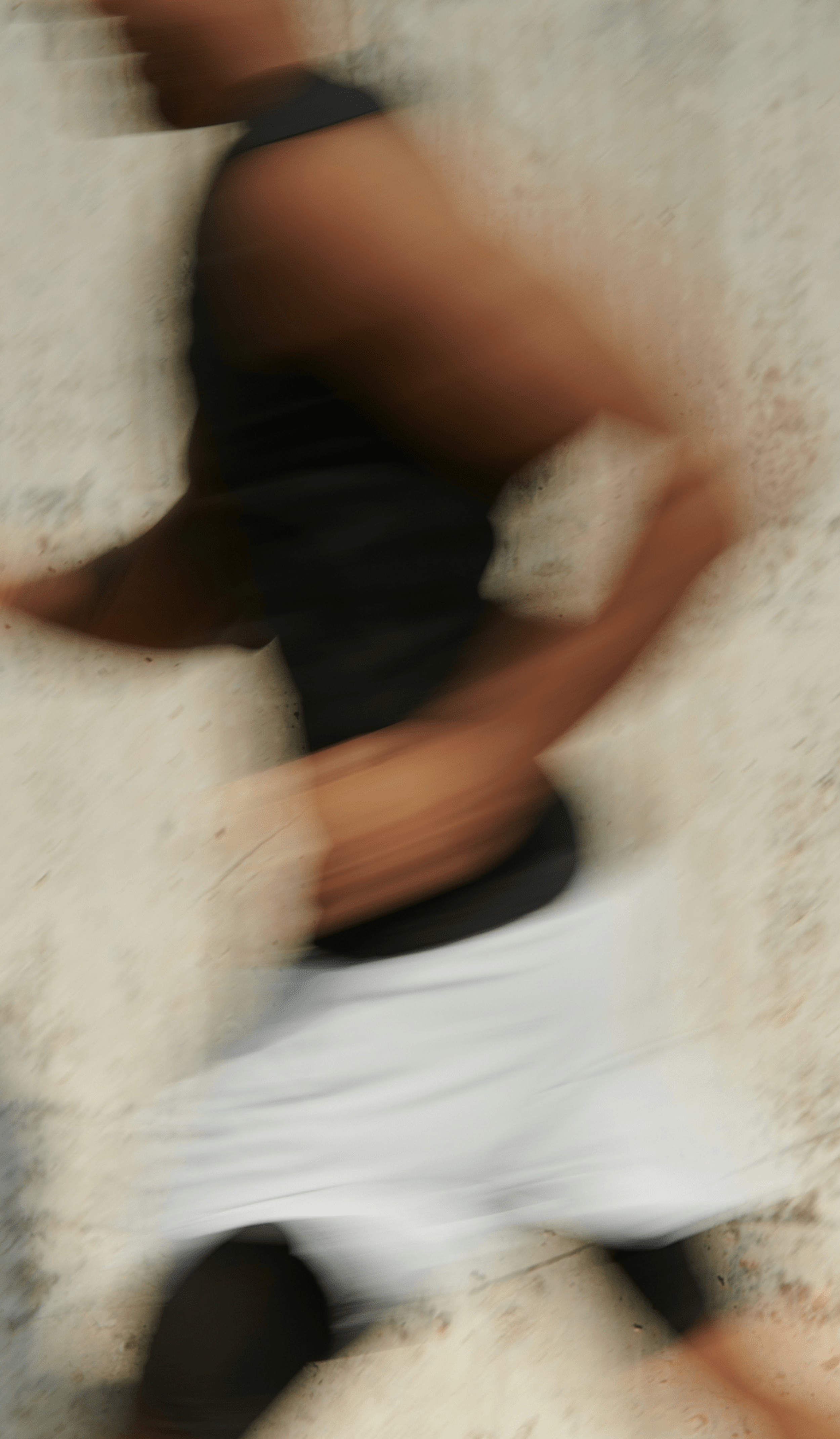Blurry motion shot of a person running past a light-colored wall