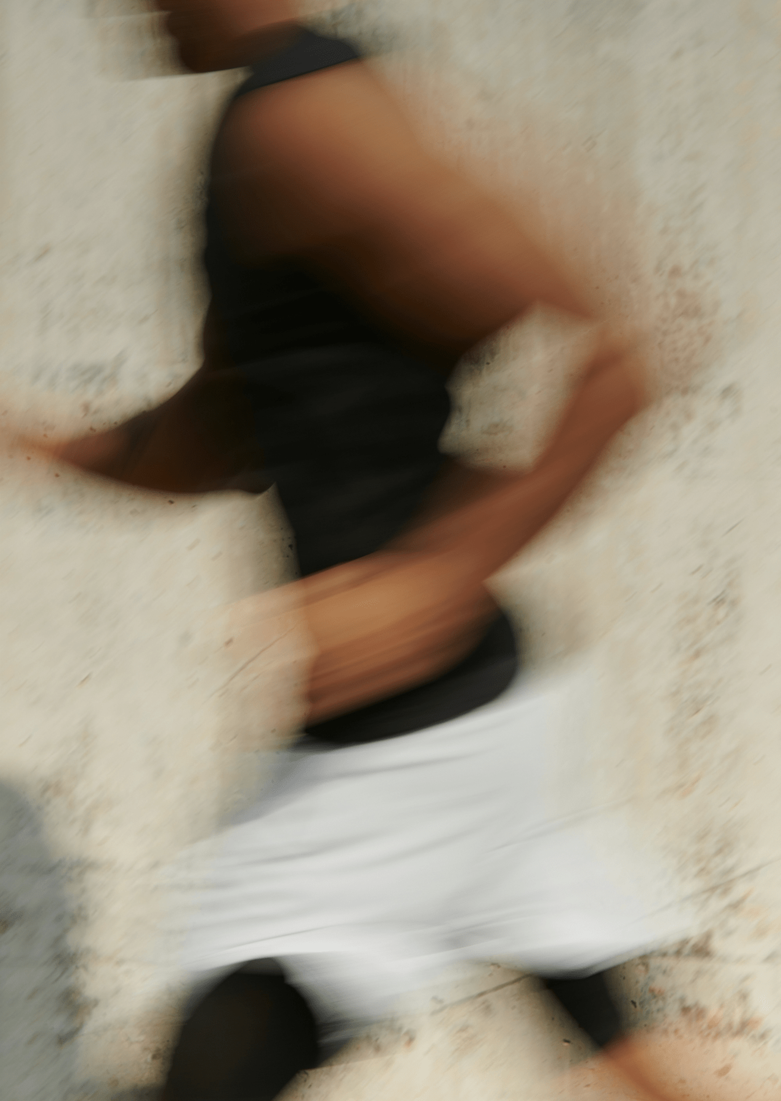 Blurry motion shot of a person running past a light-colored wall