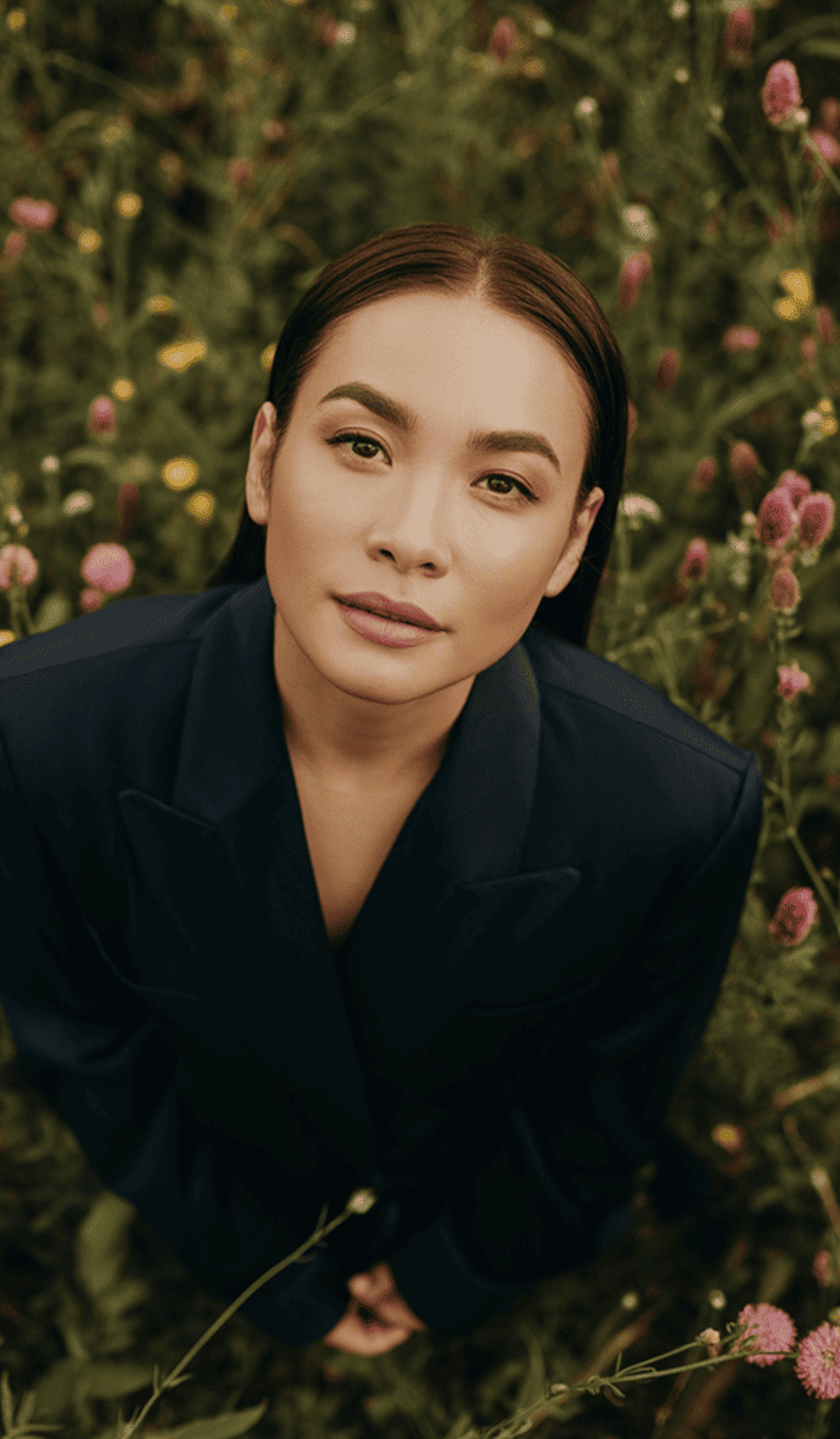 Woman in a flower field looking up