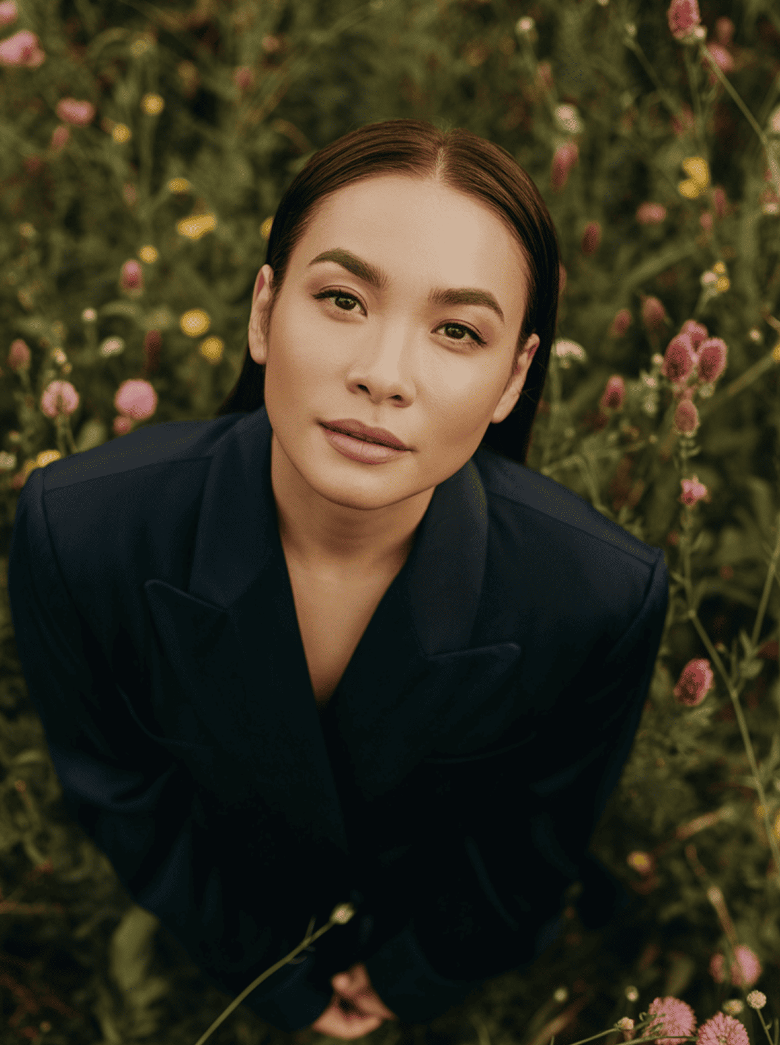 Woman in a flower field looking up