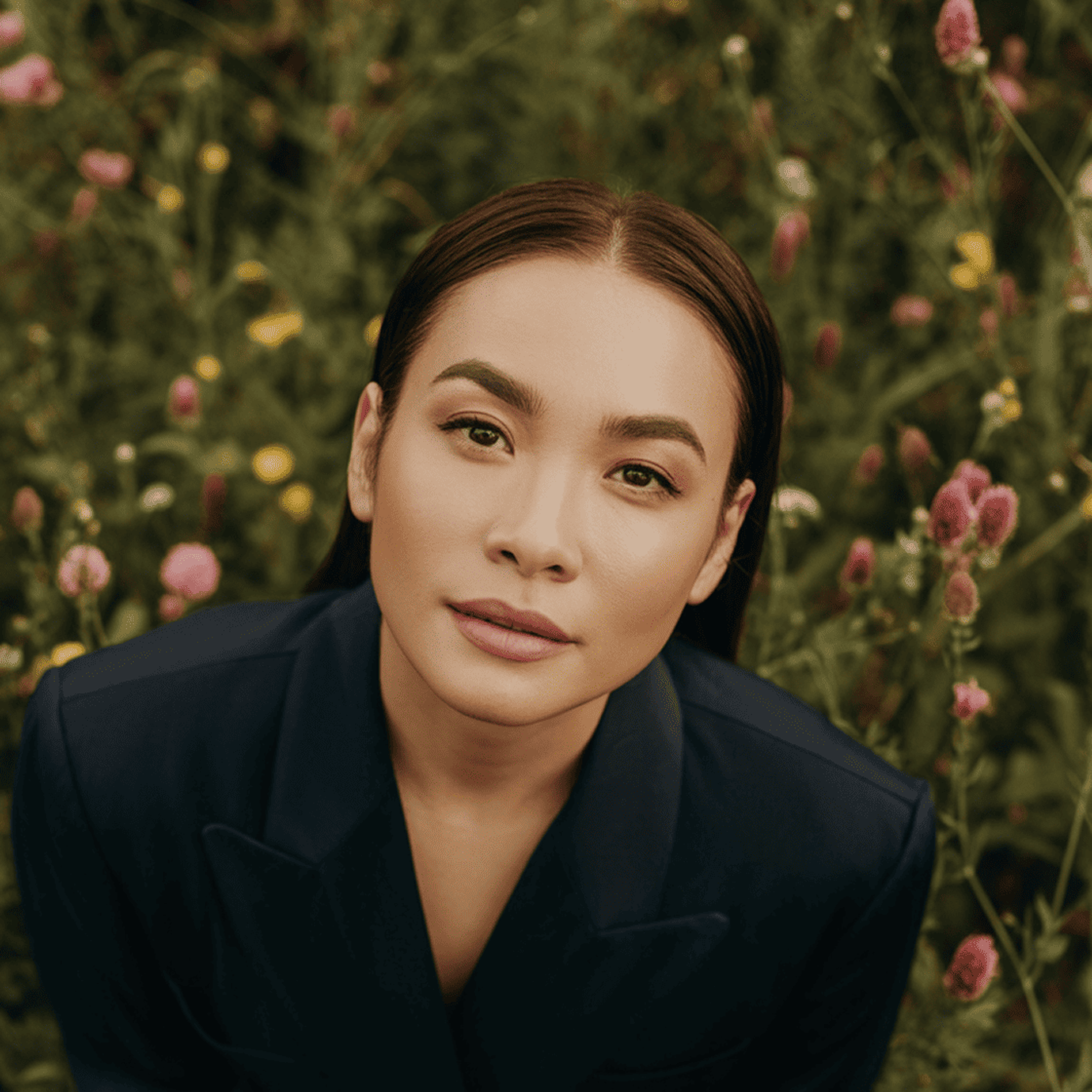 Woman in a flower field looking up